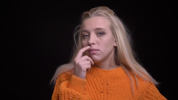 Closeup natáčení mladých docela Kavkazský žena s longblonde vlasy skepticky při pohledu na fotoaparát a pokyvovala hlavou dělat legrační výrazy obličeje — Stock video