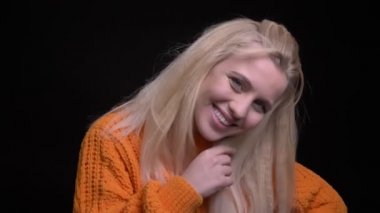 Portre çekimi genç oldukça beyaz kadın seductively gülümseyen ve kameraya bakarken saçını ile oynamak