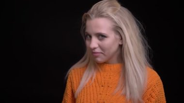 Çekingen ve utangaç gülümseyerek ve uzağa bakıyor olmak uzun sarı saçlı genç çekici beyaz kadın portre çekimleri