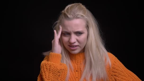 Closeup shoot of young attractive caucasian female with long blonde hair getting a headache in front of the camera — Stock Footage Closeup shoot of young attractive caucasian female with long blonde hair getting a headache in front of the camera Royalty Free Stock Video