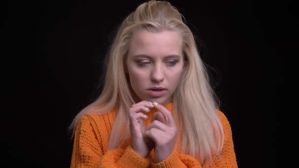 Closeup shoot of young pretty caucasian female with long blonde hair being thoughtful and remembering something smiling — Stock Video