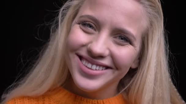 Closeup σουτ του ελκυστική Καυκάσιος κοπέλα με τα ξανθά μαλλιά είναι όμορφα και χαριτωμένα χαμογελώντας ενώ βλέπουν τα φωτογραφικών μηχανών — Αρχείο Βίντεο