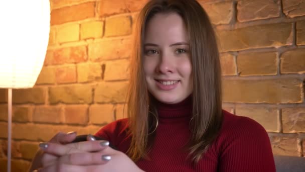 Closeup shoot of young attractive plump female looking at camera and smiling in a cozy apartment indoors — Stock Video