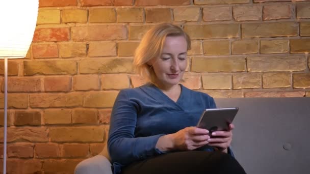 Closeup schieten van hoge Kaukasische vrouw met behulp van de tablet en tonen van groene chroma scherm met camera glimlachen binnenshuis — Stockvideo