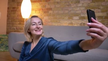 Yaşlılar beyaz kadın telefon gülümseyen ve kameranın önünde poz selfie 'ler alarak closeup ateş