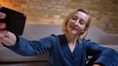 Rahat bir daire kapalı telefonda selfie 'ler yapma yaşlılar beyaz kadın closeup ateş