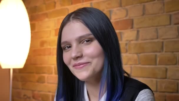 Close-up schieten van jonge mooie Kaukasische hipster vrouw met geverfd haar te kijken naar camera en glimlachen — Stockvideo