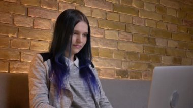 Genç çekici beyaz hipster kadın, boyalı saçlı dizüstü bilgisayarda bir komedi izlerken ve kapalı gülüyor çekim çekim