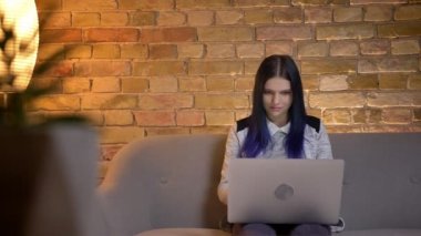 Evde kanepede oturan laptop yazarak boyalı saç ile genç çekici beyaz hipster kadın closeup ateş