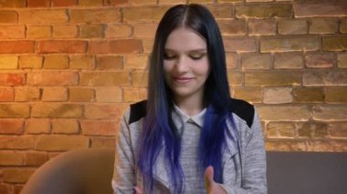 Tablet kullanarak genç güzel beyaz hipster kadın closeup çekim ve kamera rahat ev kapalı gülümseyen yeşil ekran gösteren