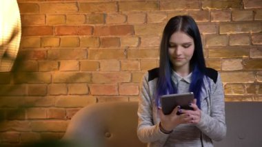 Tablet kullanarak ve kamera kapalı yeşil ekran gösteren genç güzel beyaz kadın kapatmak portre