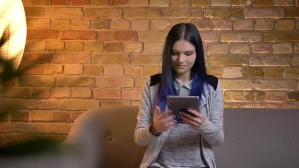 Tiro close-up de jovem muito caucasiano fêmea com cabelo tingido usando o tablet e mostrando uma tela verde para a câmera sorrindo feliz — Vídeo de Stock