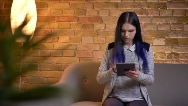 Gros plan portrait de jeune belle femme caucasienne en utilisant la tablette et montrant l'écran vert à la caméra à la maison confortable — Video