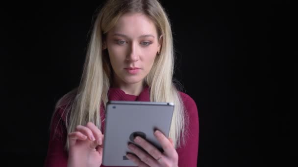 Close-up portret van jonge mooie Kaukasische vrouw met behulp van de Tablet krijgt opgewonden en verrast tijdens het kijken naar camera — Stockvideo