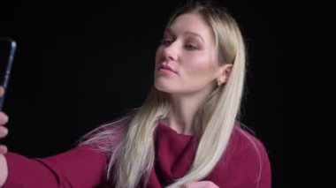 Telefonda selfies alarak ve kamera önünde poz genç oldukça beyaz kadın portre çekimleri