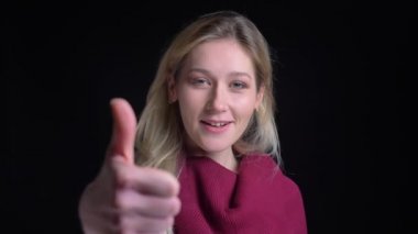 Genç güzel beyaz kadın bir başparmak yukarı gösteren ve kameranın önünde gülümseyen closeup portre