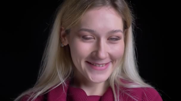 Closeup macro retrato de jovem encantadora mulher caucasiana sorrindo alegremente e posando na frente da câmera com fundo isolado em preto — Vídeo de Stock