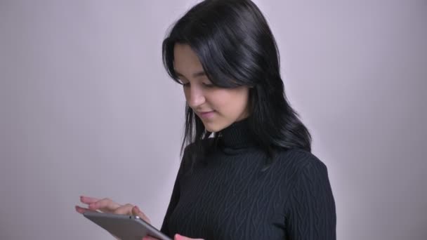 Primer plano de brote de joven atractiva hembra caucásica utilizando la tableta y mostrando la pantalla verde a la cámara sonriendo — Vídeo de stock