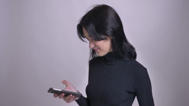 Крупним планом знімок молодої досить кавказької чорноволоса жінка переглядає по телефону і реагує на повідомлення в соціальних мережах — стокове відео