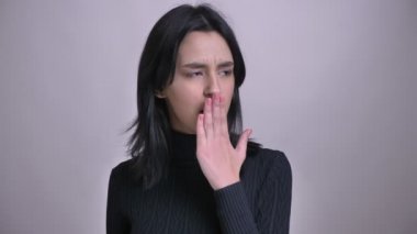 Genç güzel beyaz siyah saçlı kadın portresi closeup sıkılmış olmak ve bir esneme kamera önünde yapma