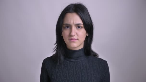 Closeup shoot of young attractive black-haired caucasian female waving her head in token ogf disagreement looking straight at camera — Stock Video