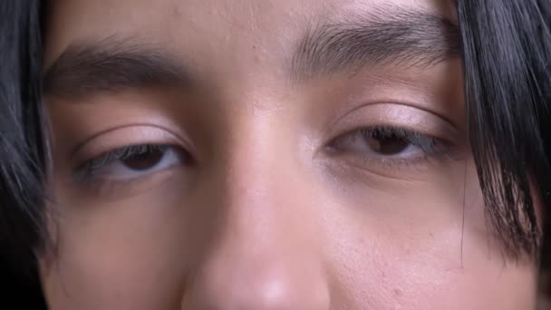 Retrato de cerca de una joven guapa hembra caucásica con ojos marrones mirando directamente a la cámara en contemplación — Vídeos de Stock