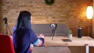Closeup çekim genç çekici kadın video Blogger telefonda konuşuyor ve rahat bir daire içinde kapalı işaret akış