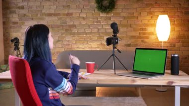 Genç çekici beyaz kadın blogger video streaming portre çekimi canlı ve neşeyle fotoğraf makinesinde konuşan.