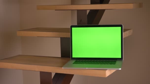 Крупним планом знімок ноутбука з зеленим екраном, що лежить на сходах в офісі в приміщенні — стокове відео