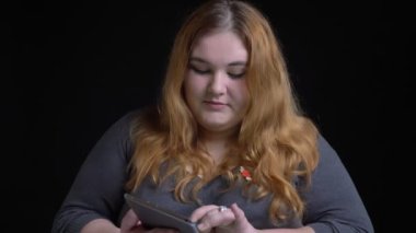 Portre çekimi kaderi kilolu tableti kullanarak ve yeşil renk ekran kamera ve gülümseyen gösterilen beyaz kadın