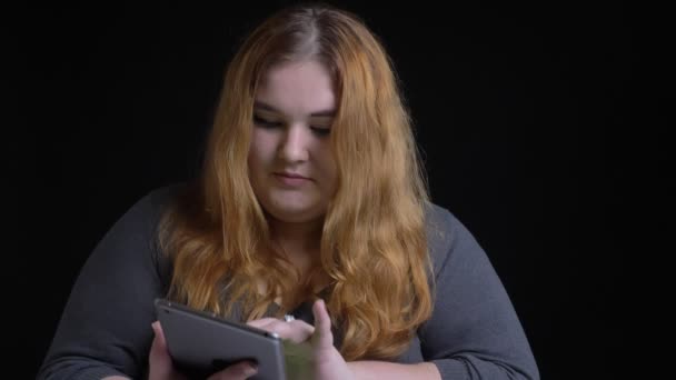 Sesión de primer plano de la joven mujer caucásica con sobrepeso usando la tableta y mostrando la pantalla verde a la cámara — Vídeos de Stock