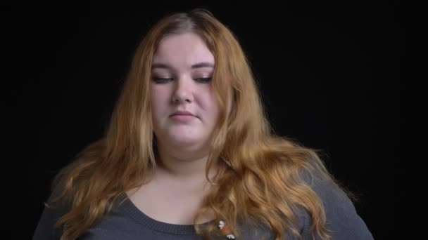 Съемки крупным планом толстой белой женщины, расстроенной и подавленной, смотрящей прямо в камеру — стоковое видео