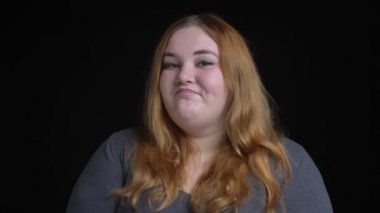 Closeup çekim genç kilolu beyaz kadın gülümseyerek ve anlaşma in token of başını sallayarak kamera bakıyor