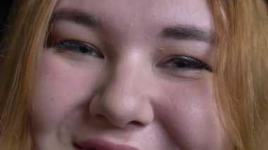 Closeup gri gözler gülümseyen neşeli yüz ifadesi ile kamera düz seyir ile genç kilolu kadın yüzü ateş