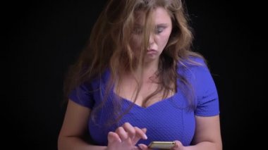 Orta yaşlı beyaz femaletexting arka plan üzerine siyah izole kamera önünde telefonda closeup portresi