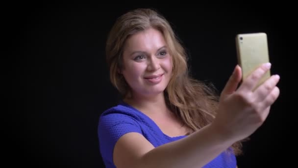 Closeup schieten van volwassen Kaukasische vrouw nemen van selfies op de telefoon glimlachend en poseren voor de camera — Stockvideo