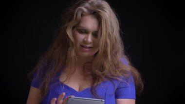 Closeup ateş tablet kullanma ve yeşil ekran kamera-yapı gülümseyen için gösterilen yetişkin beyaz kadın