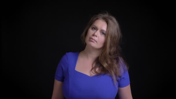 Съемка крупным планом красивой белой женщины средних лет с брюнетками, смотрящей прямо и позирующей перед камерой — стоковое видео