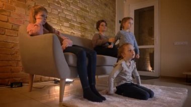 Aile portre profil beyaz anne ve üç kızı rahat ev ortamında film seyretme.