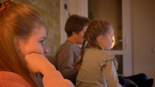 Retrato de família no perfil de mãe e filhas caucasianas assistindo filme em ambiente acolhedor casa . — Vídeo de Stock