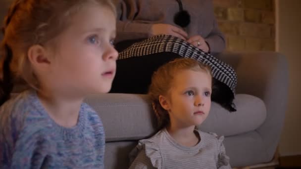 Close-up portret in profiel van kleine Kaukasische meisjes kijken naar film met groot vermaak in gezellige thuis. — Stockvideo