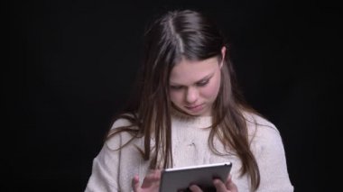 Sonra kameraya bakıyor ve arka plan ile gülümseyen tablet kullanarak genç olumlu beyaz kadın portresi portre siyah izole