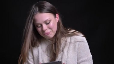 Tablet kullanma ve neşeyle gülerek kamera önünde genç oldukça beyaz esmer kadın portresi portre