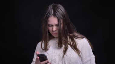 Portre portre genç çekici beyaz kadın jhappily gülüyor ve kameraya bakarak telefon tarama