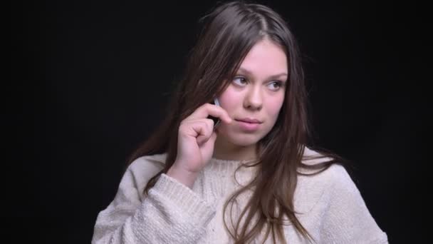 Крупним планом знімок молодої досить кавказької жінки має випадкову розмову по телефону перед камерою — стокове відео