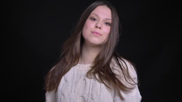 Ein Porträt der jungen attraktiven kaukasischen Frau, die mit flatternden Haaren vor der Kamera posiert und lacht — Stockvideo