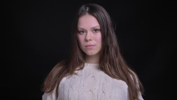 Retrato de close-up da jovem bela modelo feminina caucasiana posando na frente da câmera e sorrindo em contemplação — Vídeo de Stock