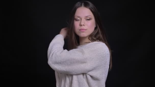 Closeup portret van jonge aantrekkelijke Kaukasische vrouwelijke model tot vaststelling van haar haren en poseren voor de camera — Stockvideo