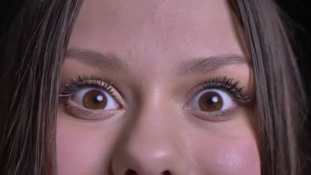 Primer plano de brote de joven bastante caucásico morena cara femenina con ojos marrones mirando directamente a la cámara con emoción — Vídeos de Stock