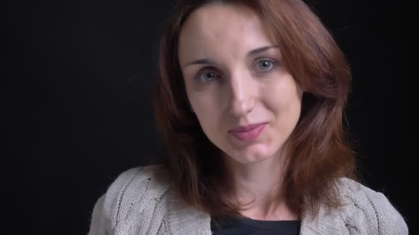 Portrét bruneta kavkazské ženy středního věku se pokorně do kamery na černém pozadí. — Stock video